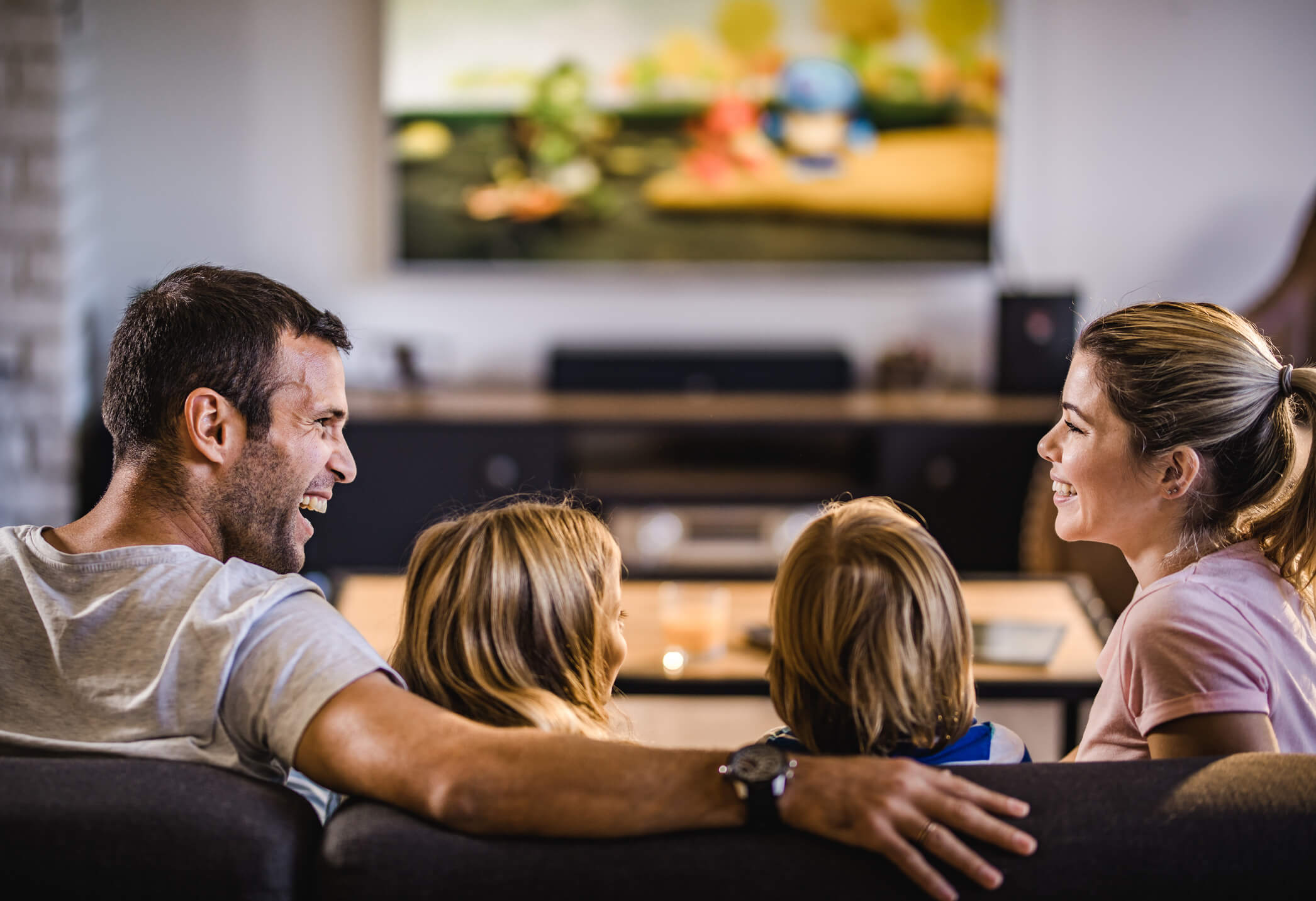 Family watching TV together at home with USACHANNELS4K IPTV service, streaming live channels, movies, and sports in HD and 4K.